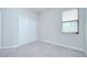 This bedroom features neutral walls, carpet flooring, closet, and a window for ample natural light at 11011 Little Blue Heron Dr, Riverview, FL 33579