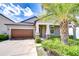 Exterior view of the home featuring a driveway, well-kept lawn, and attractive landscaping at 11011 Little Blue Heron Dr, Riverview, FL 33579