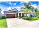 Charming single-story home with a well-manicured lawn and a two-car garage at 11011 Little Blue Heron Dr, Riverview, FL 33579