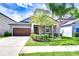 Charming single-story home with a well-manicured lawn, mature palm trees and a two-car garage at 11011 Little Blue Heron Dr, Riverview, FL 33579