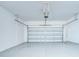 An empty garage featuring a white door and grey painted flooring and ceiling with opener at 11011 Little Blue Heron Dr, Riverview, FL 33579