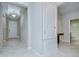 Hallway with tile flooring leading to the front door with bathroom and table to the right at 11011 Little Blue Heron Dr, Riverview, FL 33579