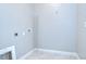 This empty laundry room has tile flooring and simple, utilitarian design at 11011 Little Blue Heron Dr, Riverview, FL 33579