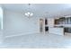 Open living area with tile flooring, chandelier, modern lighting and easy access to the kitchen at 11011 Little Blue Heron Dr, Riverview, FL 33579