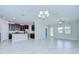 Open-concept living room with tile flooring, modern lighting, and seamless kitchen access at 11011 Little Blue Heron Dr, Riverview, FL 33579