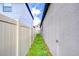 Narrow side yard with grass, showcasing the property line and space between homes at 11011 Little Blue Heron Dr, Riverview, FL 33579