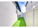 Side yard features green grass and a white vinyl fence with an exterior white stucco wall at 11011 Little Blue Heron Dr, Riverview, FL 33579