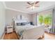 Bright bedroom with a white bed, plush pillows, and a window overlooking a tropical garden at 1205 Sweet Gum Dr, Brandon, FL 33511