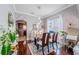 Bright dining room with wood floors, a glass table, and views into the kitchen and living room at 1205 Sweet Gum Dr, Brandon, FL 33511