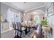 Open concept dining room with wood floors, a glass table, and views into the kitchen and living room at 1205 Sweet Gum Dr, Brandon, FL 33511