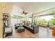 Relaxing screened lanai with wicker seating, tile flooring, ceiling fan, pillows, and an exterior view at 1205 Sweet Gum Dr, Brandon, FL 33511