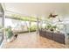 Spacious screened lanai with tile flooring, ceiling fans, plants, and a comfortable seating area for entertaining at 1205 Sweet Gum Dr, Brandon, FL 33511