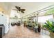 Large screened lanai with tile flooring, ceiling fan, multiple plants, and an exterior view at 1205 Sweet Gum Dr, Brandon, FL 33511