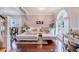 Elegant living room with wood floors, white leather sofa with colorful throw pillows and an arched window with sheer curtains at 1205 Sweet Gum Dr, Brandon, FL 33511