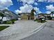 Street view of a tan two-story home with an attached garage and paver driveway in a residential neighborhood at 1205 Sweet Gum Dr, Brandon, FL 33511