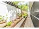 Walkway with a white privacy fence, palm trees, flower beds, and access to the screened lanai at 1205 Sweet Gum Dr, Brandon, FL 33511