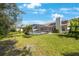 Spacious backyard featuring verdant lawn, lush foliage, and a screened pool, perfect for outdoor entertaining at 12405 Pathway Ct, Riverview, FL 33569