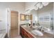 A full bathroom featuring double sinks, granite countertops, and a door leading to a walk-in closet at 12405 Pathway Ct, Riverview, FL 33569