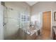 A bathroom featuring a separate tub and shower with clear glass, and tile flooring at 12405 Pathway Ct, Riverview, FL 33569