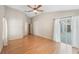 A bright bedroom features hardwood floors, neutral walls, ceiling fan, and a glass sliding door to a patio at 12405 Pathway Ct, Riverview, FL 33569