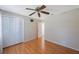 A bright bedroom featuring hardwood floors and a ceiling fan at 12405 Pathway Ct, Riverview, FL 33569