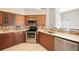 A kitchen with stainless steel appliances, wood cabinets, tile backsplash, and white countertops at 12405 Pathway Ct, Riverview, FL 33569