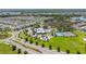An aerial view of the community pool, clubhouse, and tennis courts surrounded by lush greenery and homes at 12607 Pensacola Ct, Riverview, FL 33579