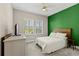 Bedroom with a bright green accent wall, plantation shutters, and a ceiling fan at 12607 Pensacola Ct, Riverview, FL 33579