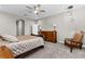 Comfortable bedroom with a ceiling fan, a wooden dresser, a chair, and neutral carpeting at 12607 Pensacola Ct, Riverview, FL 33579