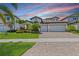 Charming single-Gathering home showcasing a well-manicured lawn, mature landscaping and a three-car garage at 12607 Pensacola Ct, Riverview, FL 33579