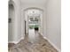 Inviting foyer featuring an arched ceiling, herringbone-patterned wood floors, and elegant light fixtures at 12607 Pensacola Ct, Riverview, FL 33579