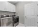 Laundry room featuring modern washer, dryer, white cabinets, and tiled floors at 12607 Pensacola Ct, Riverview, FL 33579