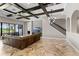 Open-concept living room featuring herringbone floors, wood beam ceiling, and stone accent wall with television at 12607 Pensacola Ct, Riverview, FL 33579