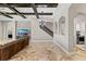 Spacious living room with wood beams, a modern light fixture, and herringbone patterned wood floors at 12607 Pensacola Ct, Riverview, FL 33579