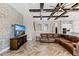 Open living room features a stone accent wall, entertainment center, and herringbone flooring at 12607 Pensacola Ct, Riverview, FL 33579