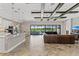Expansive living room featuring wood floors, coffered ceilings, a leather sofa, and panoramic windows to the outdoors at 12607 Pensacola Ct, Riverview, FL 33579