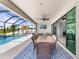 Covered patio with a dining area and comfortable seating, adjacent to the screened pool area at 12607 Pensacola Ct, Riverview, FL 33579