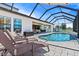 Relaxing screened-in pool area featuring a water feature, lounge chairs, and outdoor grilling area at 12607 Pensacola Ct, Riverview, FL 33579