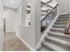 View of the staircase with a black metal railing, gray carpet, and the living room beyond at 12607 Pensacola Ct, Riverview, FL 33579