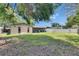 A view of the backyard from the side of the house with a screened lanai and a white privacy fence at 15820 Sapwood St, Tampa, FL 33624