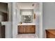Bathroom vanity with wood cabinets, white counter top, and bright lighting over large framed mirror at 15820 Sapwood St, Tampa, FL 33624