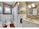 Bathroom featuring vanity with decorative mirror and shower/tub with white wainscotting and bronze fixtures at 15820 Sapwood St, Tampa, FL 33624