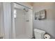 Shower with white tile and window, toilet with towel rack, and two decorative towels at 15820 Sapwood St, Tampa, FL 33624