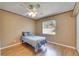 Bedroom with light wood floors, ceiling fan, and a large window with window treatments at 15820 Sapwood St, Tampa, FL 33624