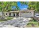Inviting exterior with an attached two-car garage, a seating bench and a well-manicured front yard and a driveway at 15820 Sapwood St, Tampa, FL 33624
