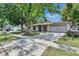 Charming home with a spacious driveway, large trees, and a well-kept lawn, perfect for outdoor enjoyment at 15820 Sapwood St, Tampa, FL 33624