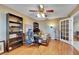Inviting home office with hardwood floors, ceiling fan, bookshelves and a glass door at 15820 Sapwood St, Tampa, FL 33624