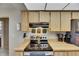 Cozy kitchen with stainless steel oven and cooktop, matching the light cabinets and countertops at 15820 Sapwood St, Tampa, FL 33624