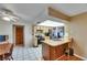 Functional kitchen featuring tile floors, wooden cabinets, and a breakfast bar perfect for casual dining and socializing at 15820 Sapwood St, Tampa, FL 33624
