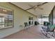 The screened lanai has a ceiling fan and seating overlooking the backyard at 15820 Sapwood St, Tampa, FL 33624